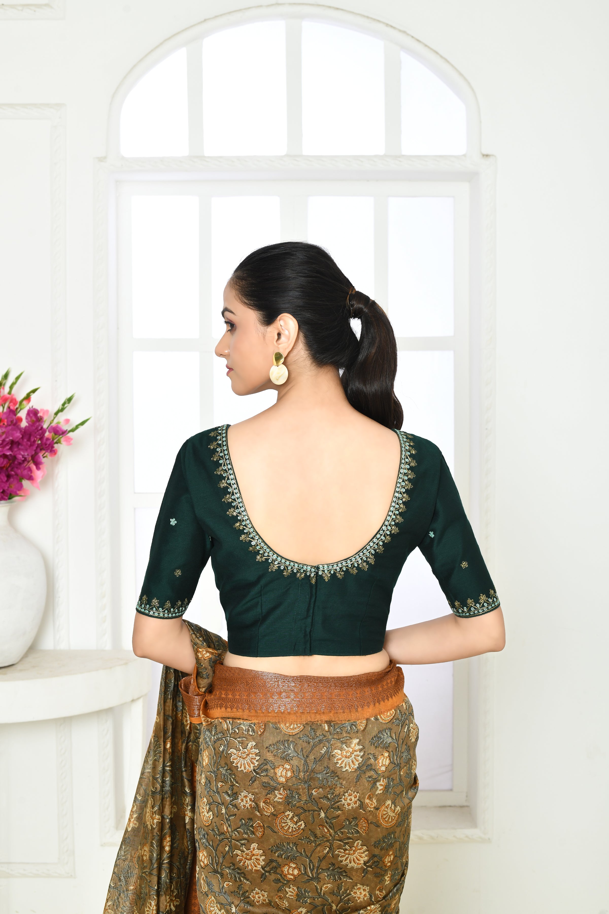 Bottle green pure raw silk elbow length blouse with golden floral embroidery in sleeves, front and back neck.