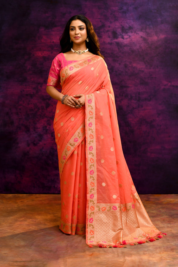 Woman wearing a peach saree with a purple background
